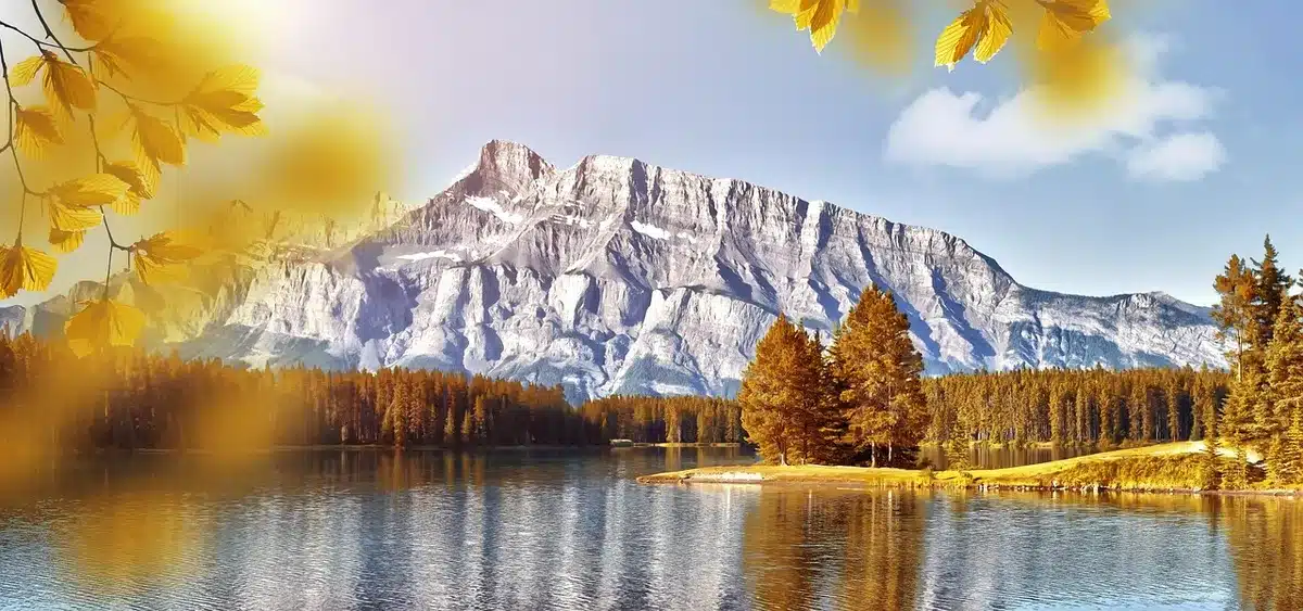 Kanu auf spiegelglattem See mit herbstlich gefärbten Uferbäumen und Reflexionen