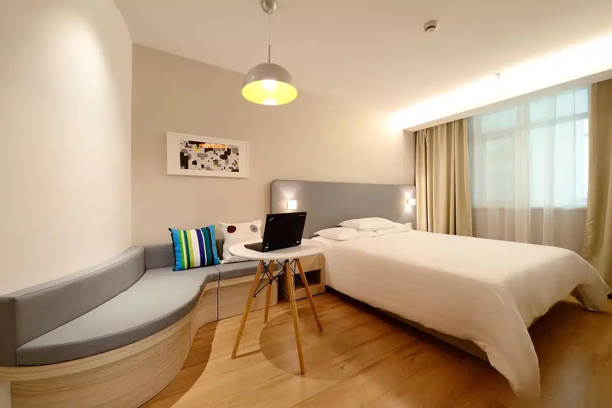 Person überprüft anonym die Nähte einer Matratze in einem Hotelzimmer
