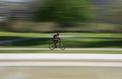 Schreibtischszene: Laptop, Lifestyle‑Magazine und Fahrradhelm auf einem Café­tisch