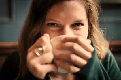 Anonymer Hotelzimmertür mit einem aufgehängten Becher im Flur bei Nacht