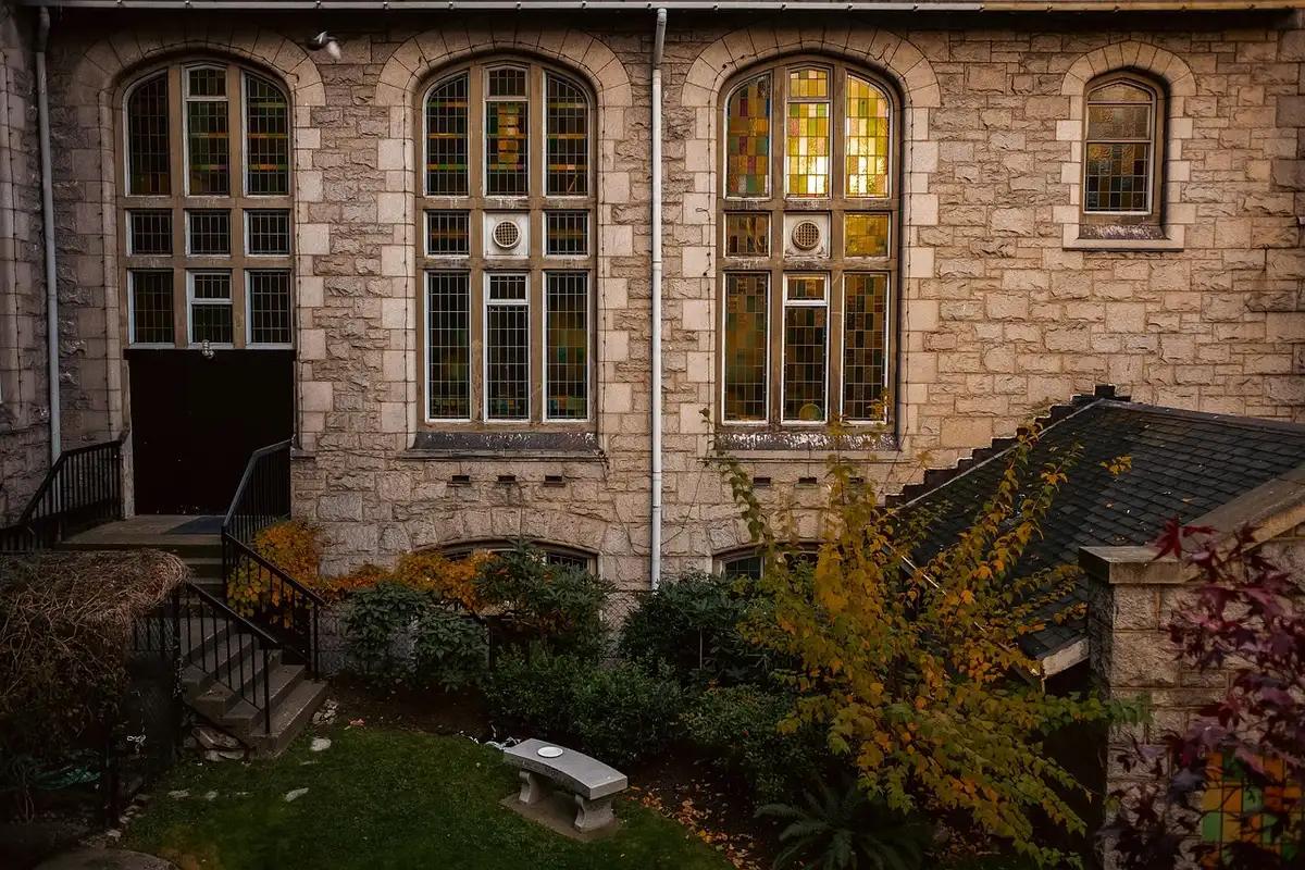 Innenhof eines Hotels unter Glasüberdachung mit Tischen und gedämpfter Beleuchtung