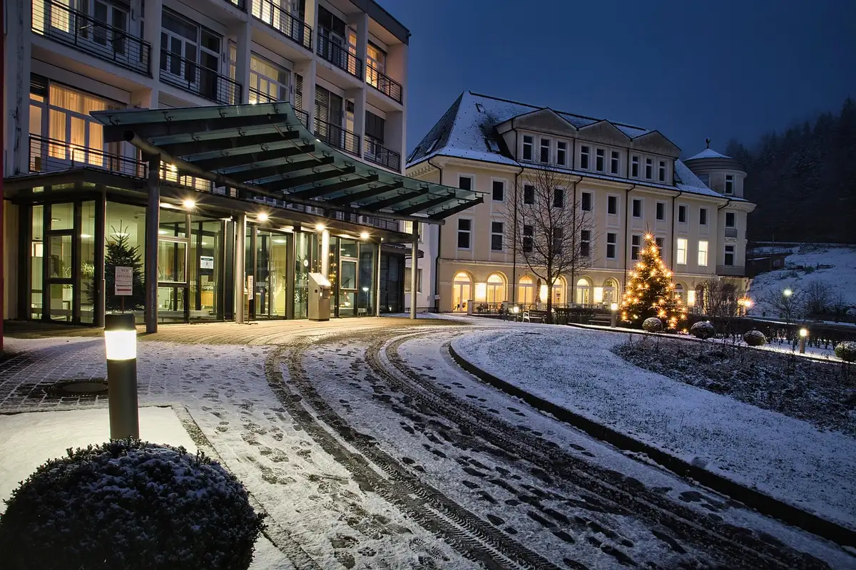 Vorderansicht eines historischen Küstenhotels mit Palmen und Meerblick